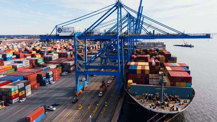 Aerial view of a container port with quay cranes and stacked containers