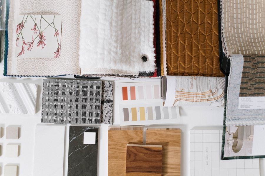 Material and fabric swatches laid out on a table with colour samples