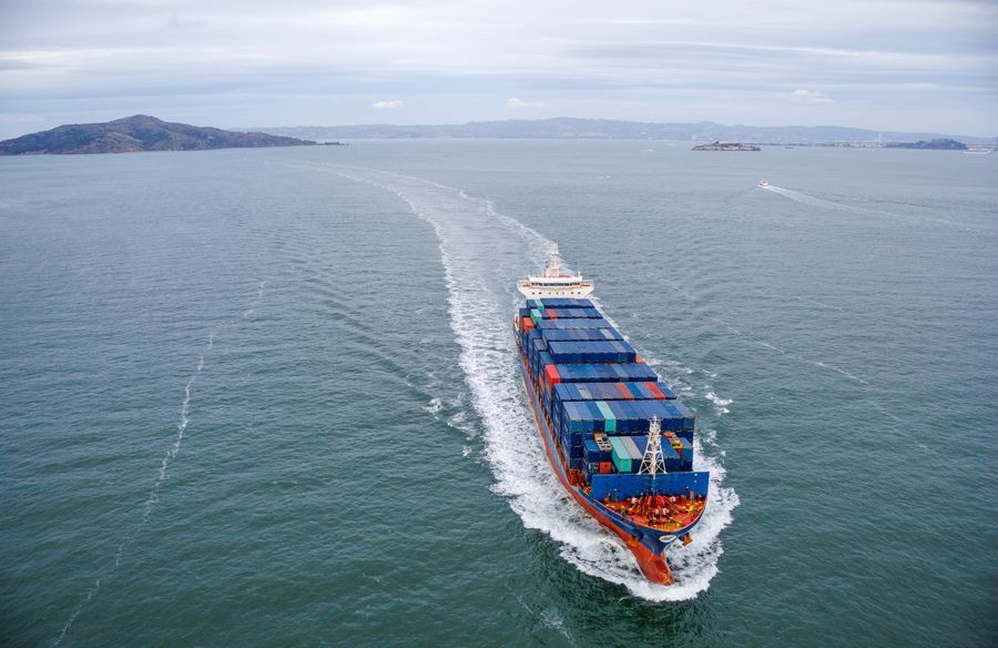 A loaded container ship at sea, seen from above