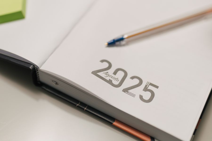 An open notebook showing the year written on a blank page, with a pen