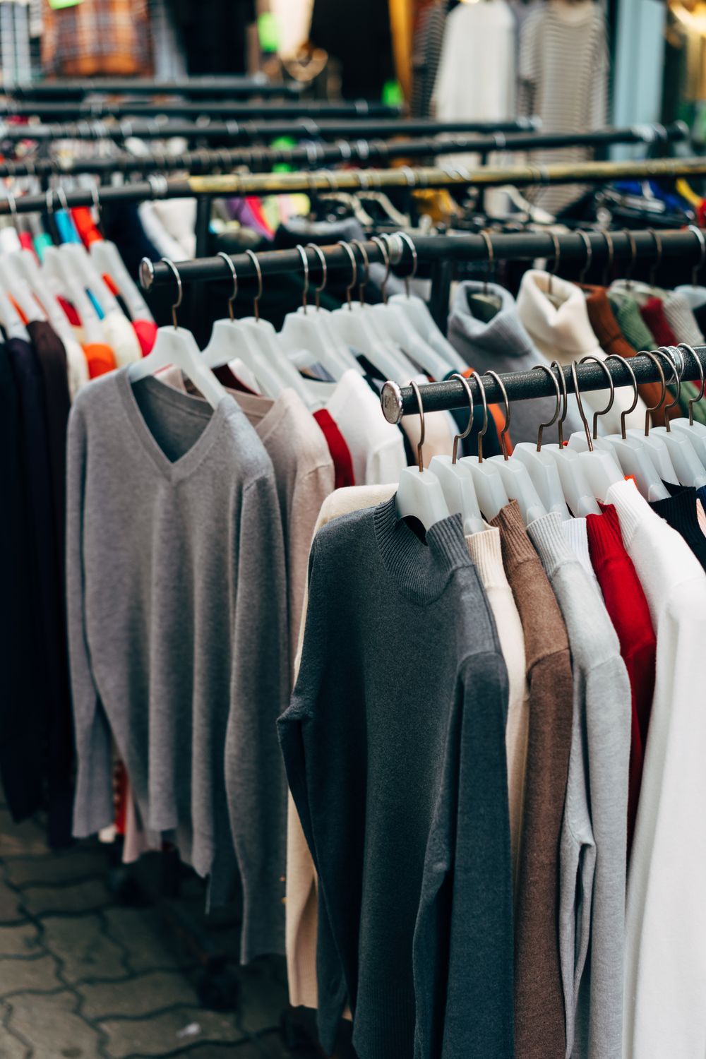 Neutral-toned garments on a retail clothing rail