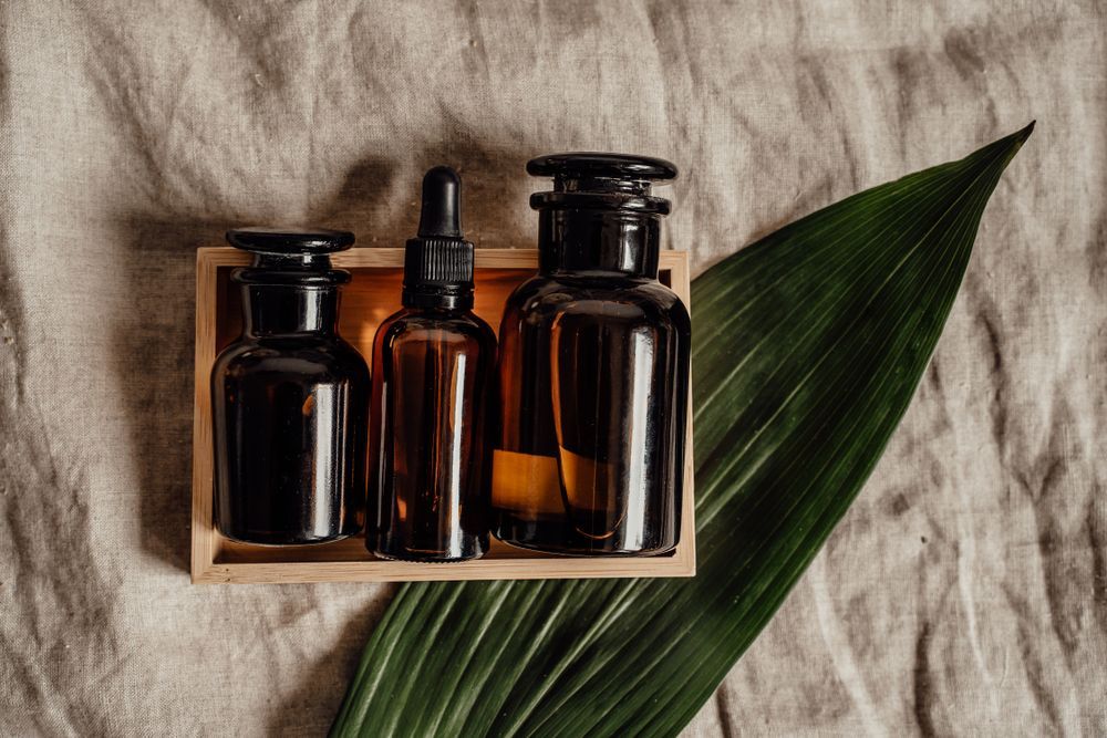 Amber glass skincare bottles in a wooden crate