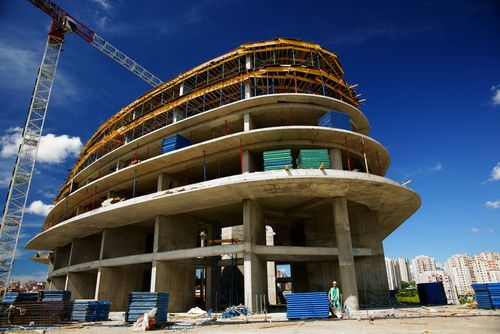 A modern building under construction with tower cranes