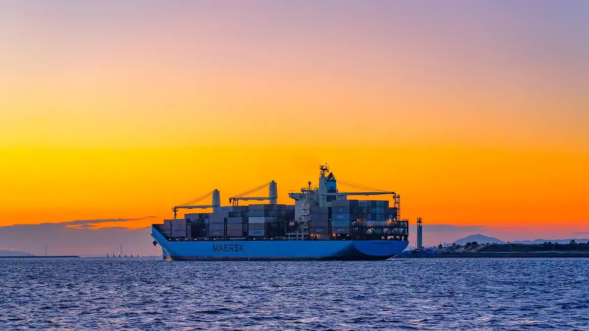 A container ship at Osaka port after sunset.