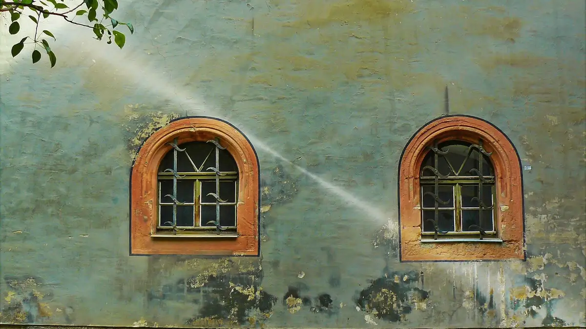 Lattice windows on a weathered house facade.