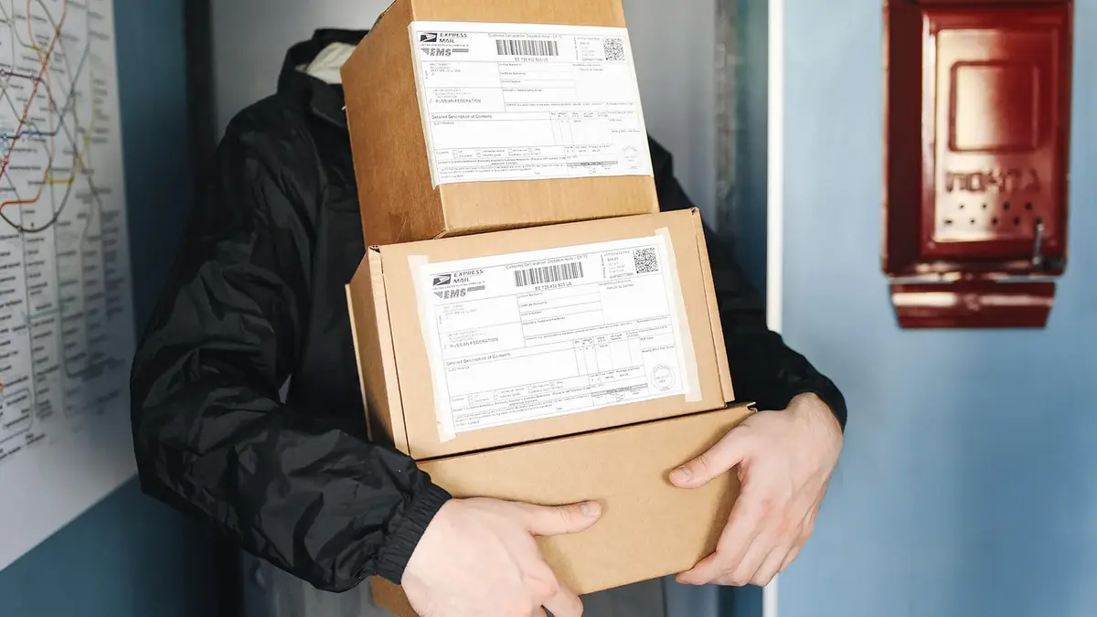 A delivery worker with parcels and boxes.