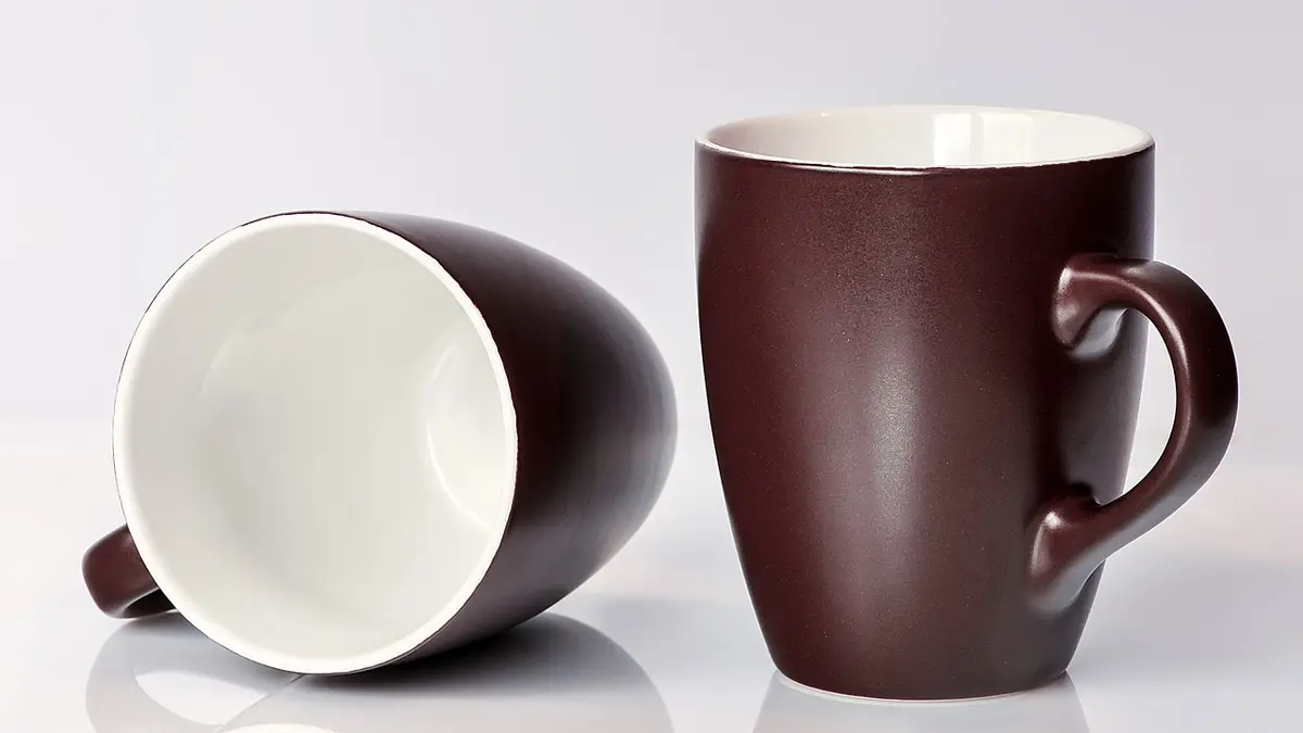 A pair of empty brown ceramic mugs.
