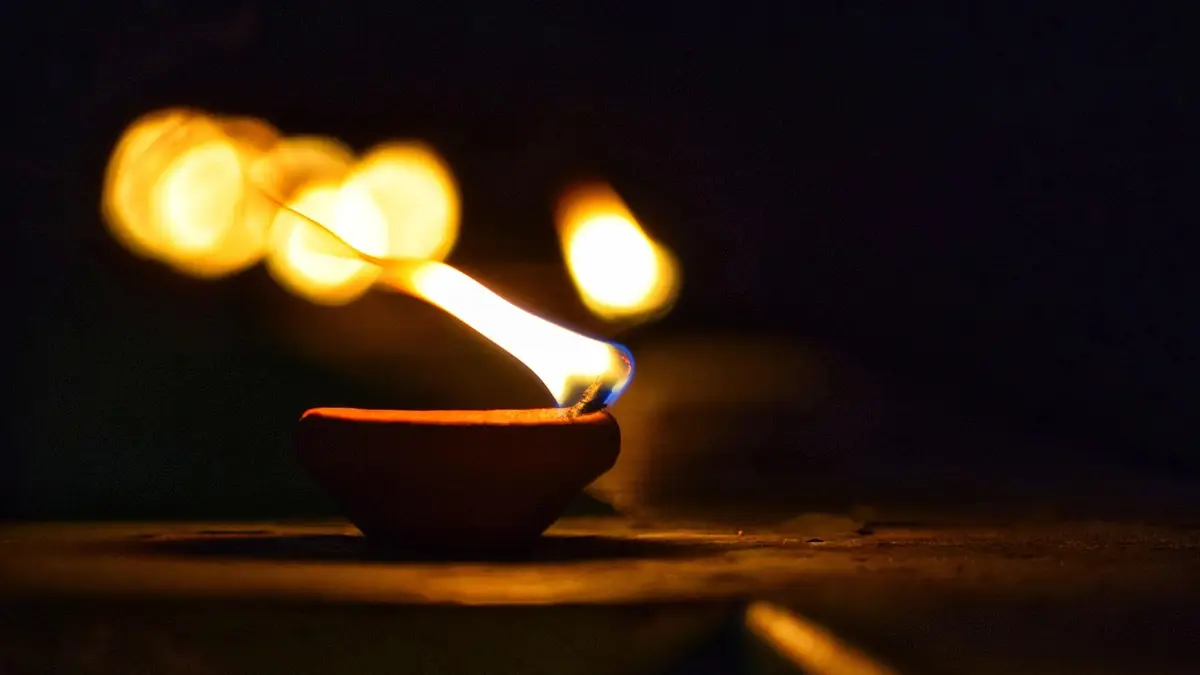 An oil lamp provides light for Diwali.