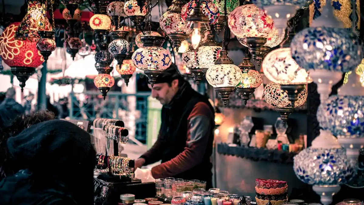 A market stall with bracelets, candles, lamps and souvenirs.