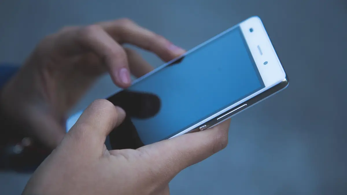 Hands using a touchscreen smartphone.