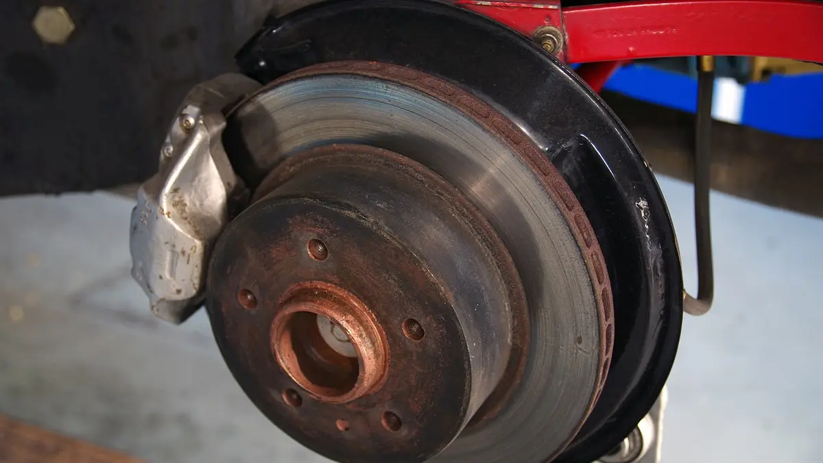 A brake disc during automotive maintenance in a workshop.