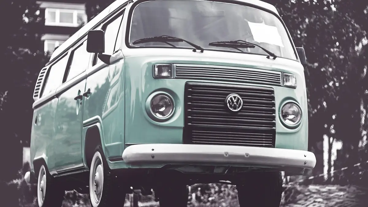 A vintage Volkswagen camper van with a bumper and headlights.
