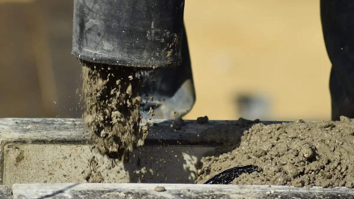A concrete pump pouring concrete at a construction site.