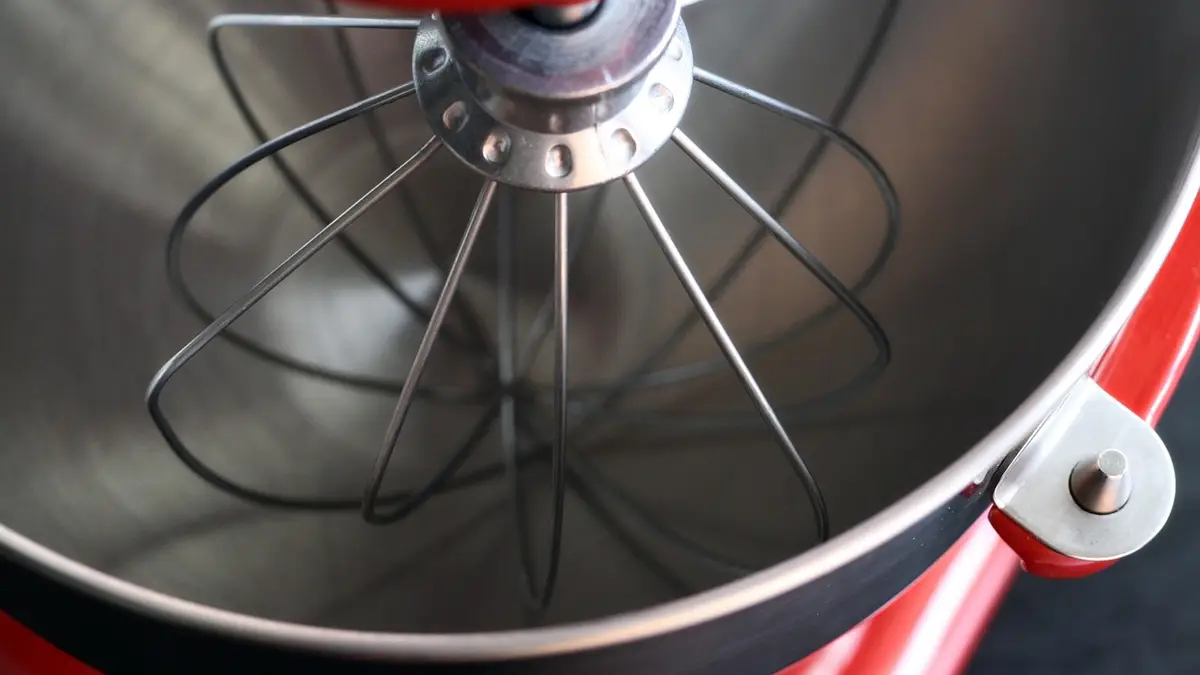 A red electric kitchen mixer with a whisk.