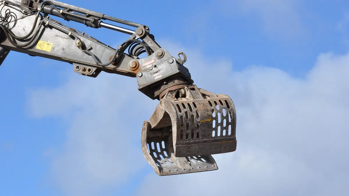 An excavator arm with a grab attachment.