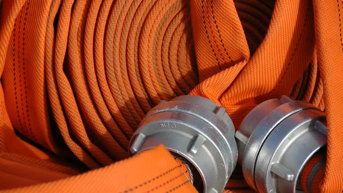 An orange fire hose with a Storz coupling.