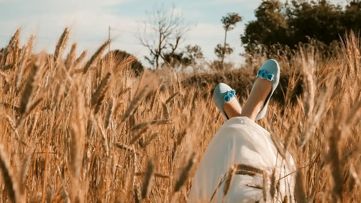 A woman wearing ballet flats in a wheat field.