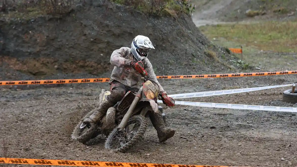 A motorcycle and helmet at an outdoor enduro competition.