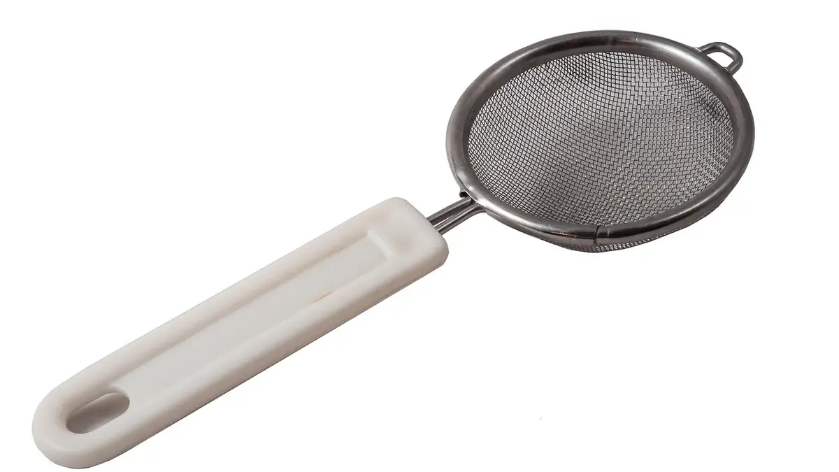 A kitchen sieve used as a tea strainer.