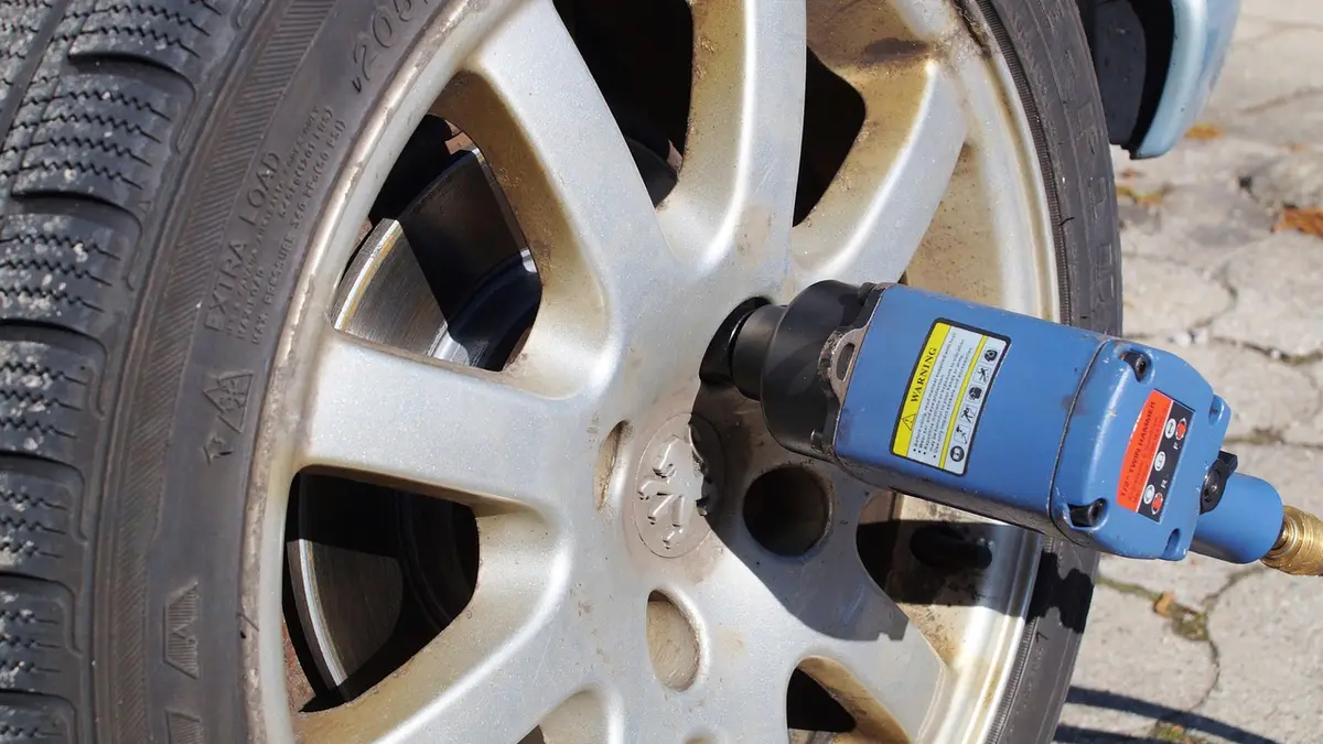 A pneumatic impact wrench used for a wheel change in a workshop.