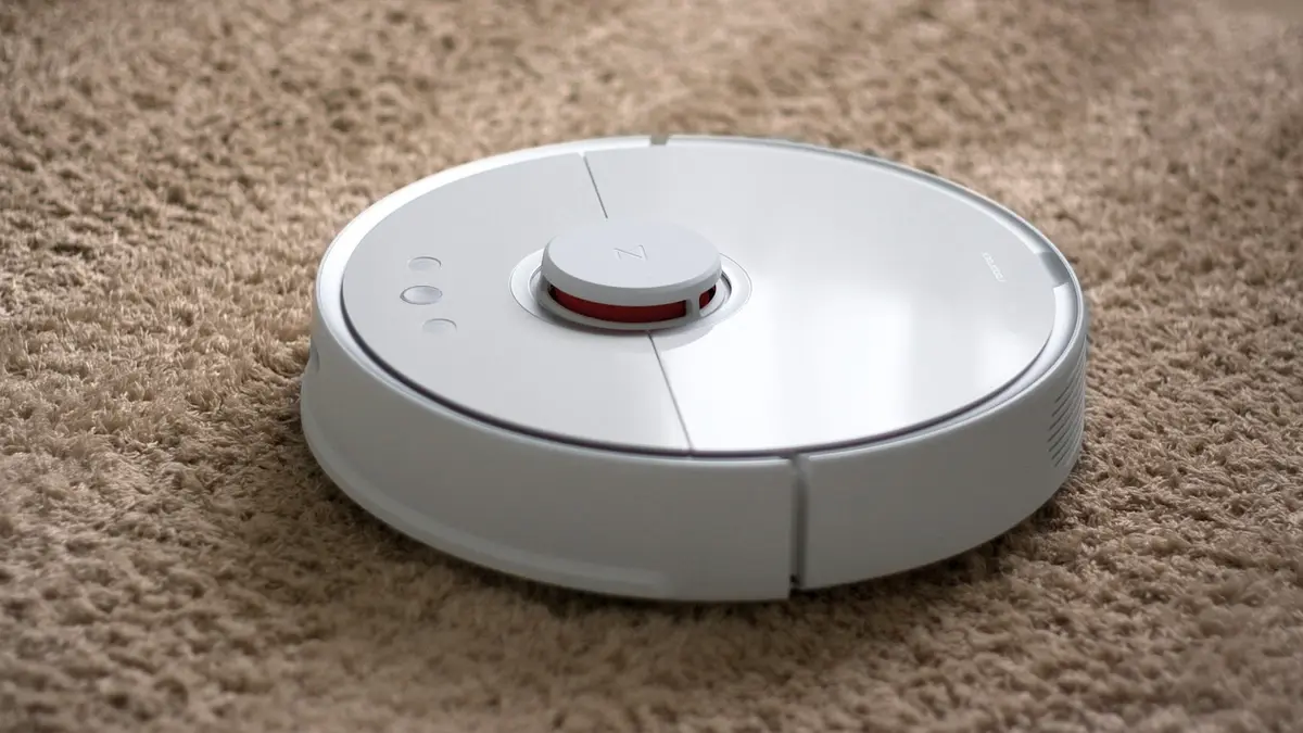 A robot vacuum cleaner on a carpet.