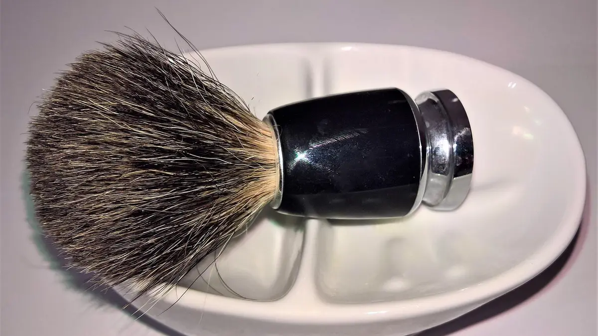 A badger-hair shaving brush with a porcelain bowl and soap dish.