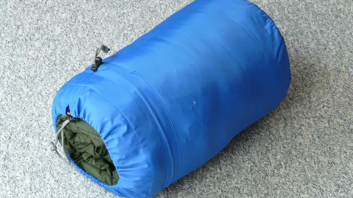 A packed sleeping bag for camping.