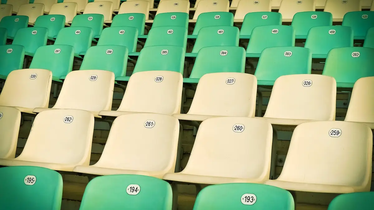 Rows of numbered plastic seats in a stadium.