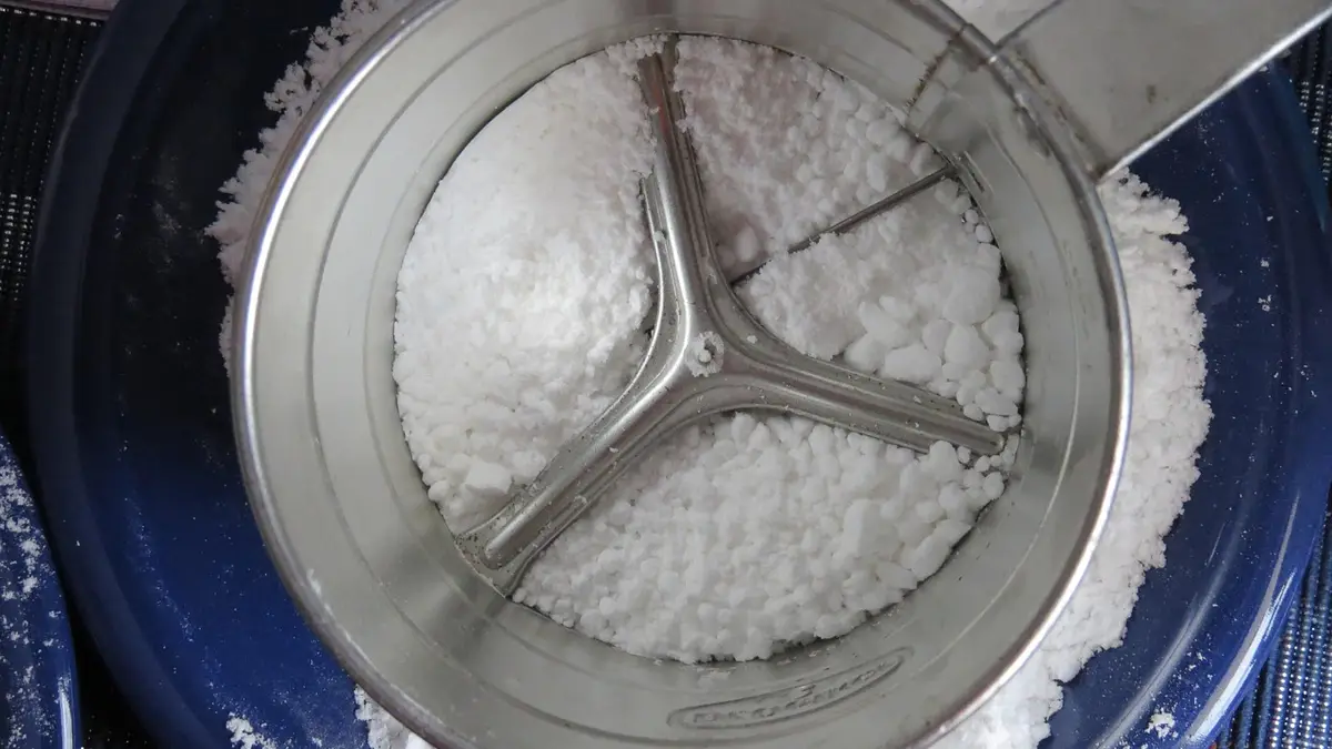 一个单手操作的金属面粉筛。