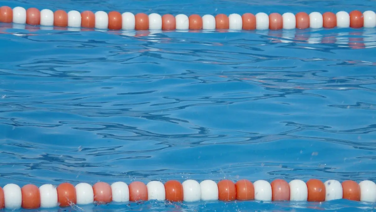 Styrofoam balls forming lane dividers in a swimming pool.