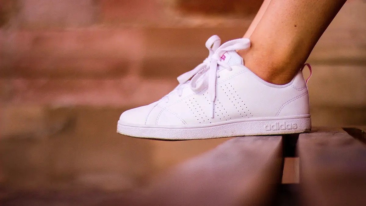 White tennis shoes on feet.