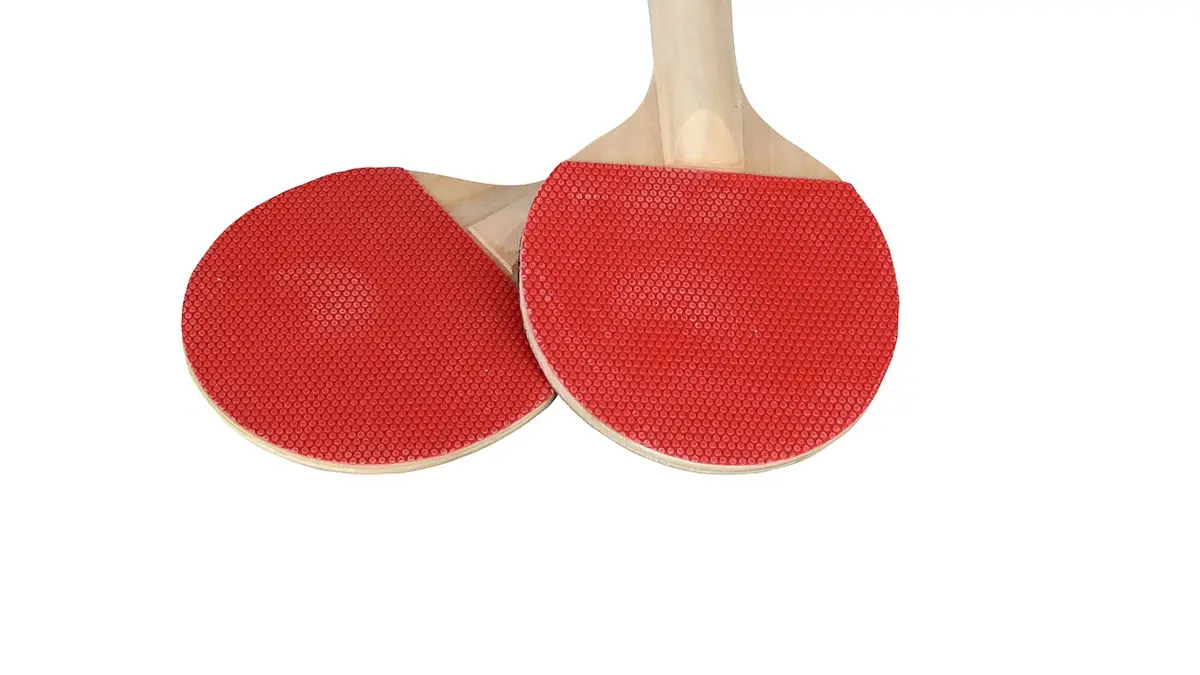 A red table tennis bat has a wooden handle.