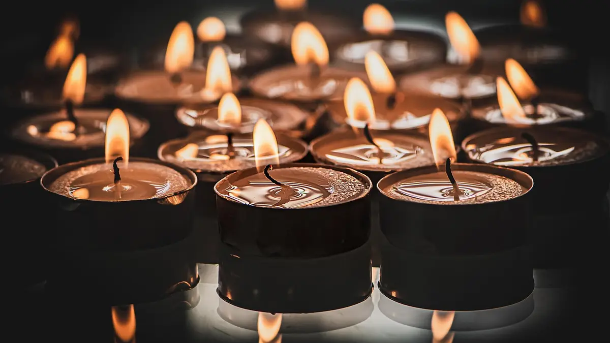 Burning tealight candles glow with visible flames and melted wax.