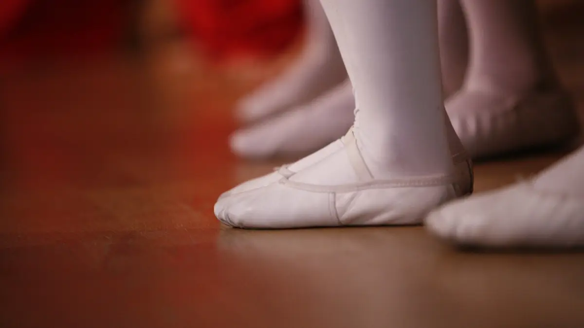 Ballet shoes are worn on a dancer's feet.