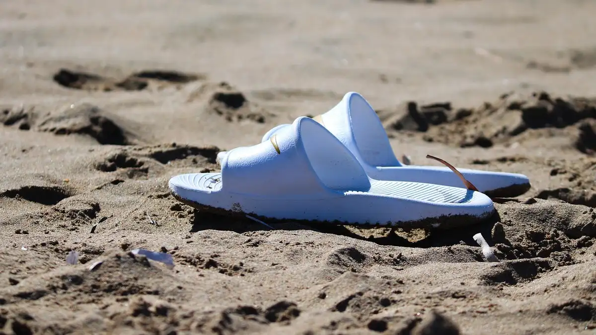 Bathing shoes on beach sand.