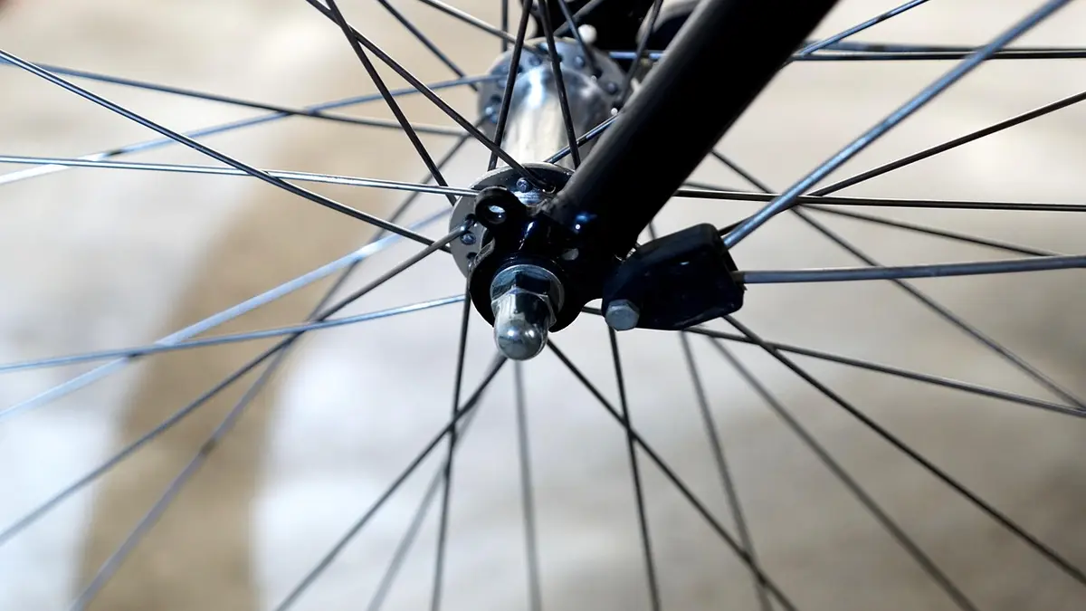 A bicycle front wheel hub with a fastening cap nut.