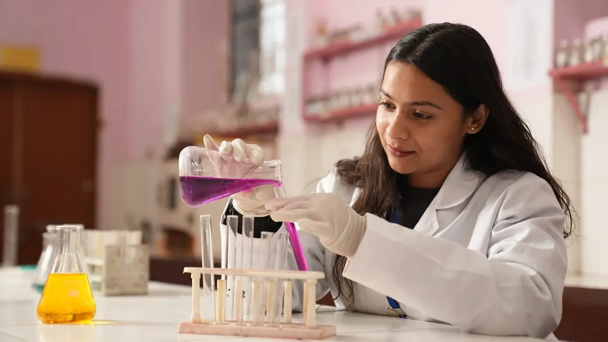 A woman in a white coat working in a laboratory.