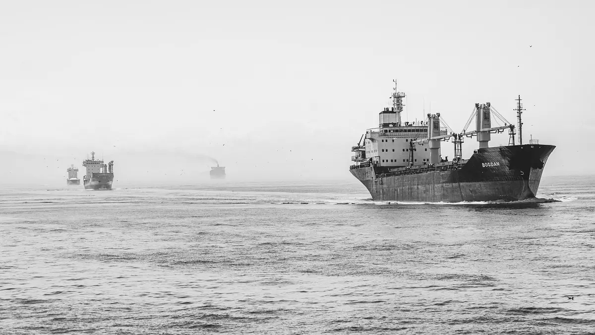 Container ships at sea in black and white.